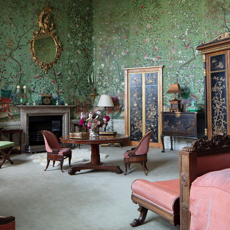 A room in Belvoir Castle with green chinoiserie wallpaper and antique furniture
