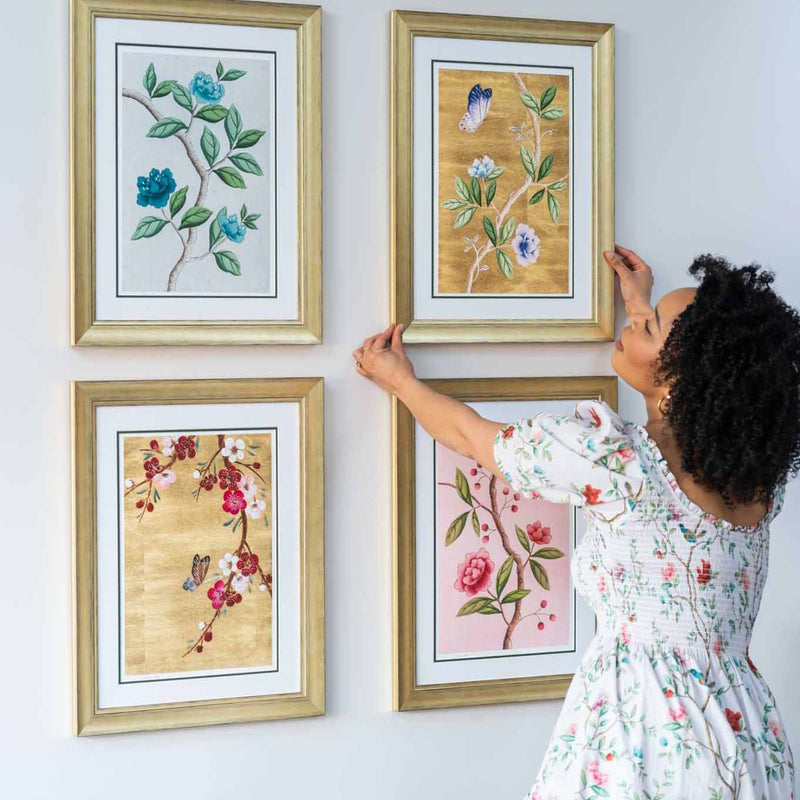 Diane Hill hanging up four chinoiserie art prints