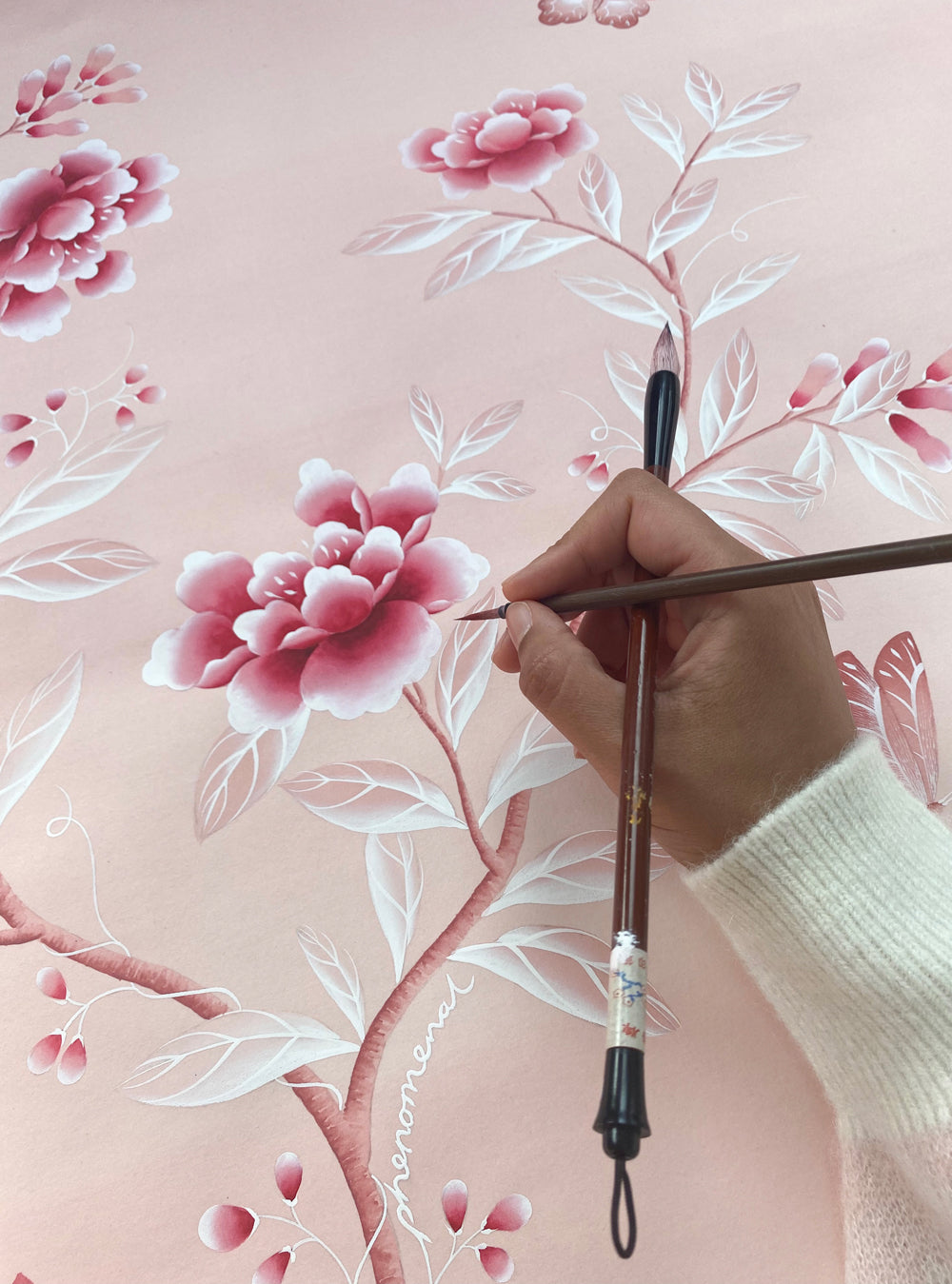 Diane Hill hand painting the design for the nap dress created by Hill House Home in collaboration with Phenomenal and Netflix, featuring her bespoke pink chinoiserie design