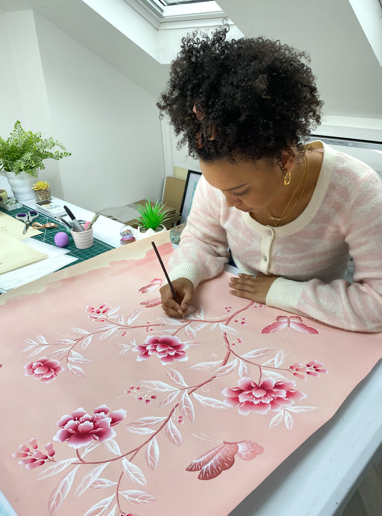 Diane Hill creating the design for the nap dress created by Hill House Home in collaboration with Phenomenal and Netflix, featuring her bespoke pink chinoiserie design