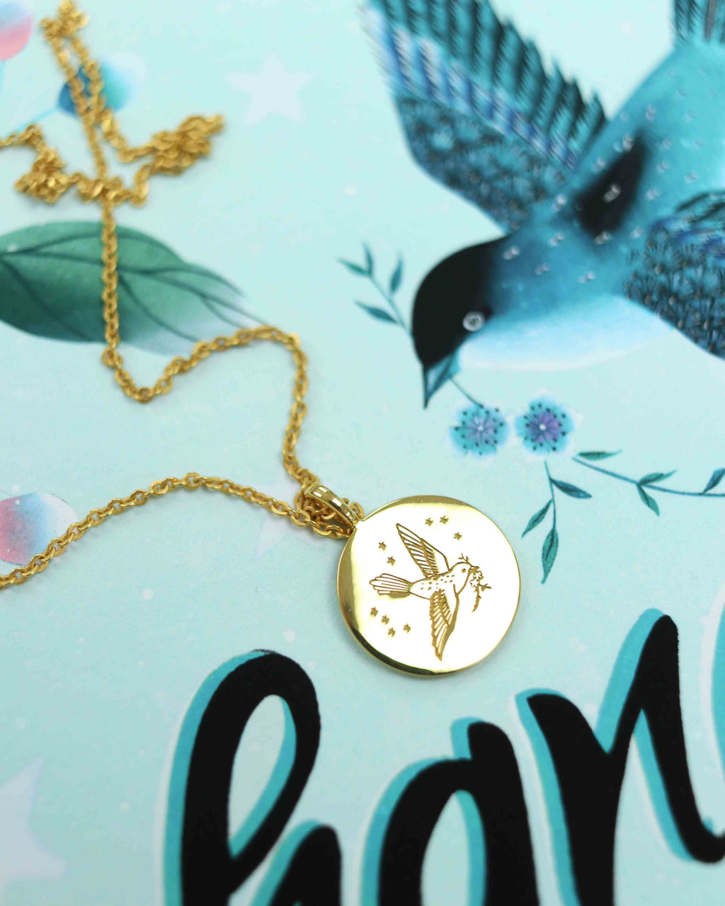 The gold coin necklace featuring an engraved bird sits upon Diane Hill's A change is gonna come artwork.