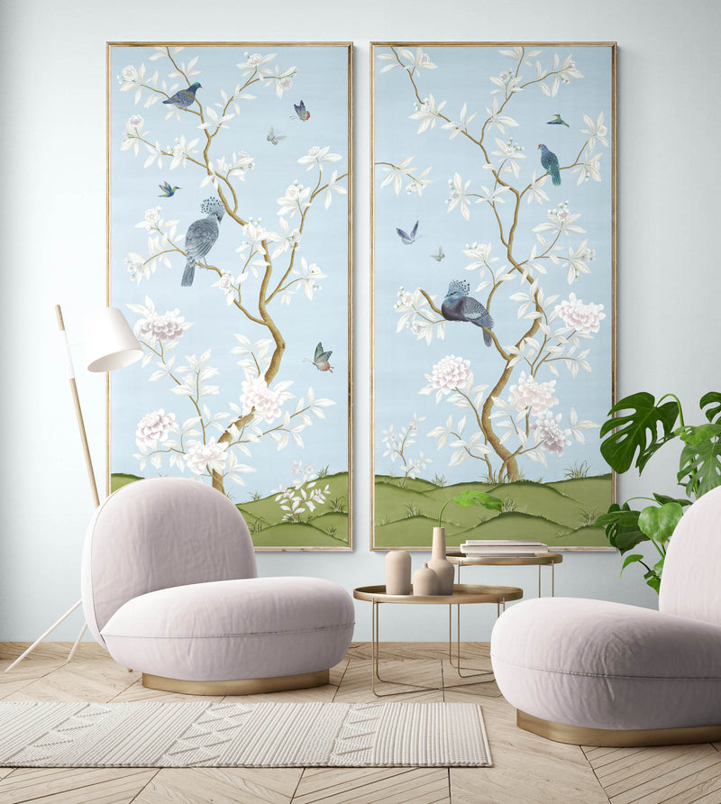 pair of 2 framed blue chinoiserie wall panel prints with botanical illustrations featuring birds, butterflies, and flowers hung on wall