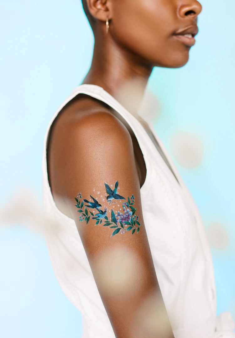 A stunning woman shows off her arm, bearing Chinoiserie inspired temporary tattoos, design by Diane Hill in collaboration with Tattly