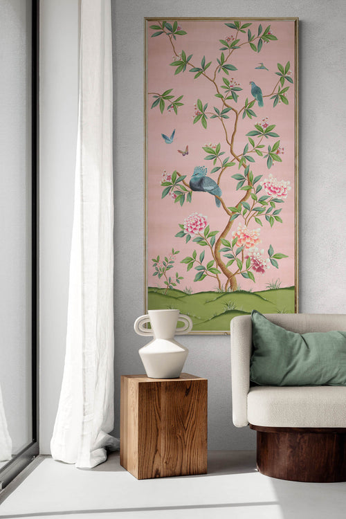 framed pink and green chinoiserie wall art panel with botanical illustrations featuring birds, butterflies, and flowers hung on wall