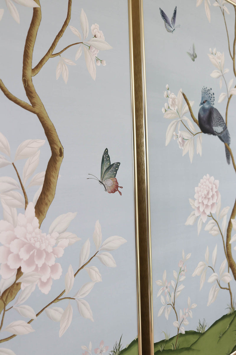 close up of 2 framed blue chinoiserie art prints featuring birds, butterflies, and flowers