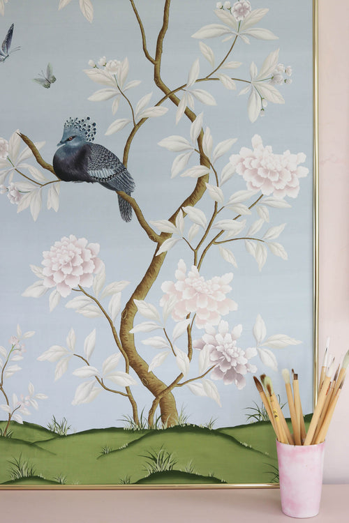 framed blue chinoiserie wall art print featuring a bird, flowers, and butterflies in Chinese painting style