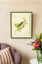 framed botanical wall art print featuring gold sparkle embellished exotic bird on tree branches with flowers hung on wall