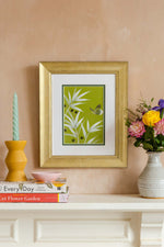 framed green and white chinoiserie wall art print featuring bamboo a butterfly hung on wall
