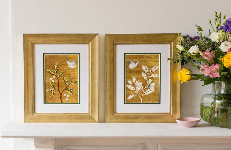 pair of framed chinoiserie wall art print featuring vintage Chinese-style butterfly and flower branch on gold background on mantle