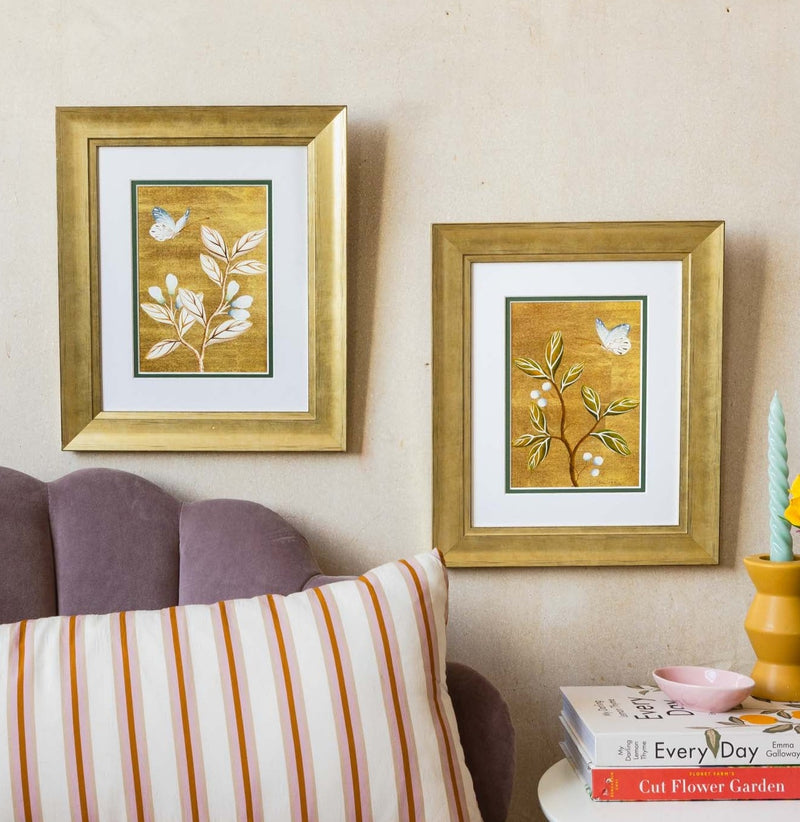 pair of framed chinoiserie wall art print featuring vintage Chinese-style butterfly and flower branch on gold background hung on wall