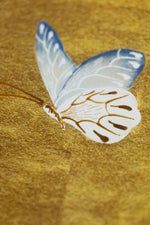 close up of chinoiserie wall art print featuring vintage Chinese-style butterfly and flower branch on gold background