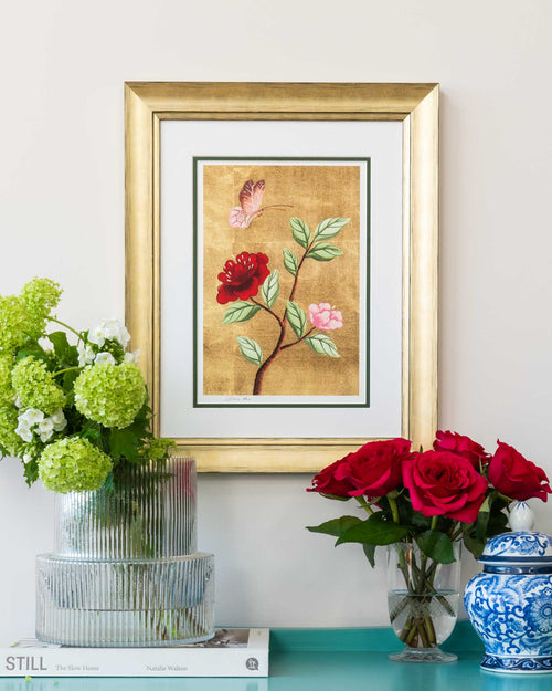 framed chinoiserie wall art print featuring vintage-style butterfly and flower branch on gold leaf background hung on wall