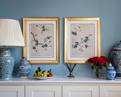 pair of framed chinoiserie wall art prints featuring Japanese-style cherry blossom branches on silver background hung on wall