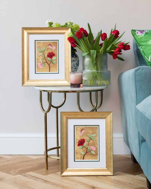 pair of framed chinoiserie wall art prints featuring vintage-style butterfly and flower branch on gold leaf background in living room
