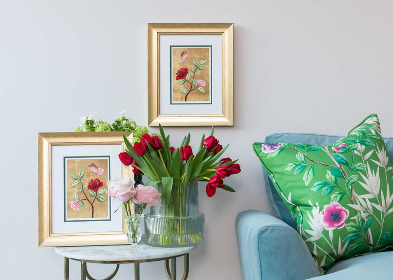 pair of framed chinoiserie wall art prints featuring vintage-style butterfly and flower branch on gold leaf background hung on wall