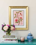 framed chinoiserie wall art print featuring pink vintage-style butterfly and flower branch on pink background hung on wall