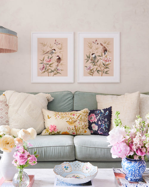 blush pink framed chinoiserie wall art prints featuring vintage style birds, butterfly and flower branches with a bamboo background hung on wall