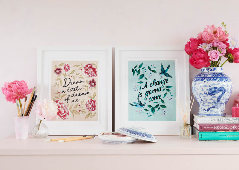 pair of colourful framed vintage-style chinoiserie wall art print featuring birds, flowers,  and branches. One contains the quote 'a change is gonna come' and the other contains the quote 'dream a little dream of me'