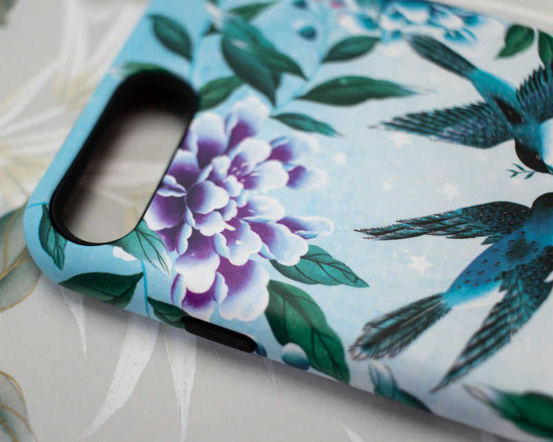 close up of blue luxury chinoiserie phone case featuring three vintage inspired birds surrounded by leaves and flowers