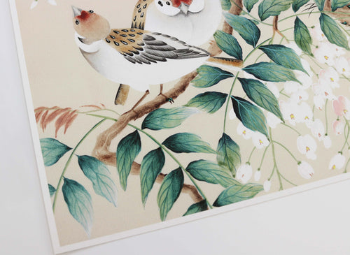 A close up of chinoiserie art print featuring two birds and then green leaves of a wisteria tree