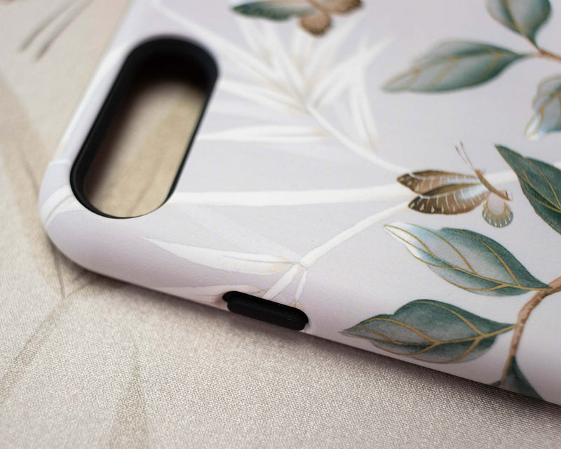 close up of Luxury phone case featuring vintage style butterflies and flower branches with a bamboo background