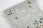 close up of pebble blue chinoiserie wall art print featuring butterflies, flower branches, and bamboo