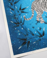 close up of blue vintage-style chinoiserie wall art print featuring a white tiger on a blue starry background