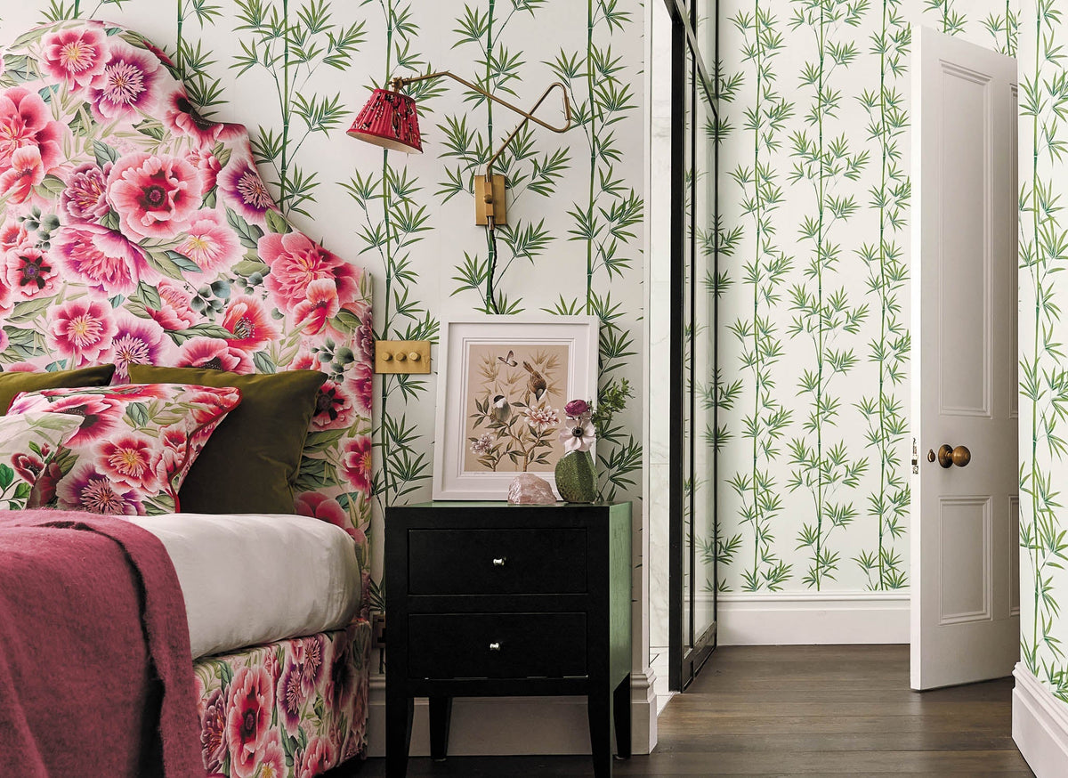 maximalist bedroom featuring Chinese wallpaper, chinoiserie art prints, and vintage floral fabric