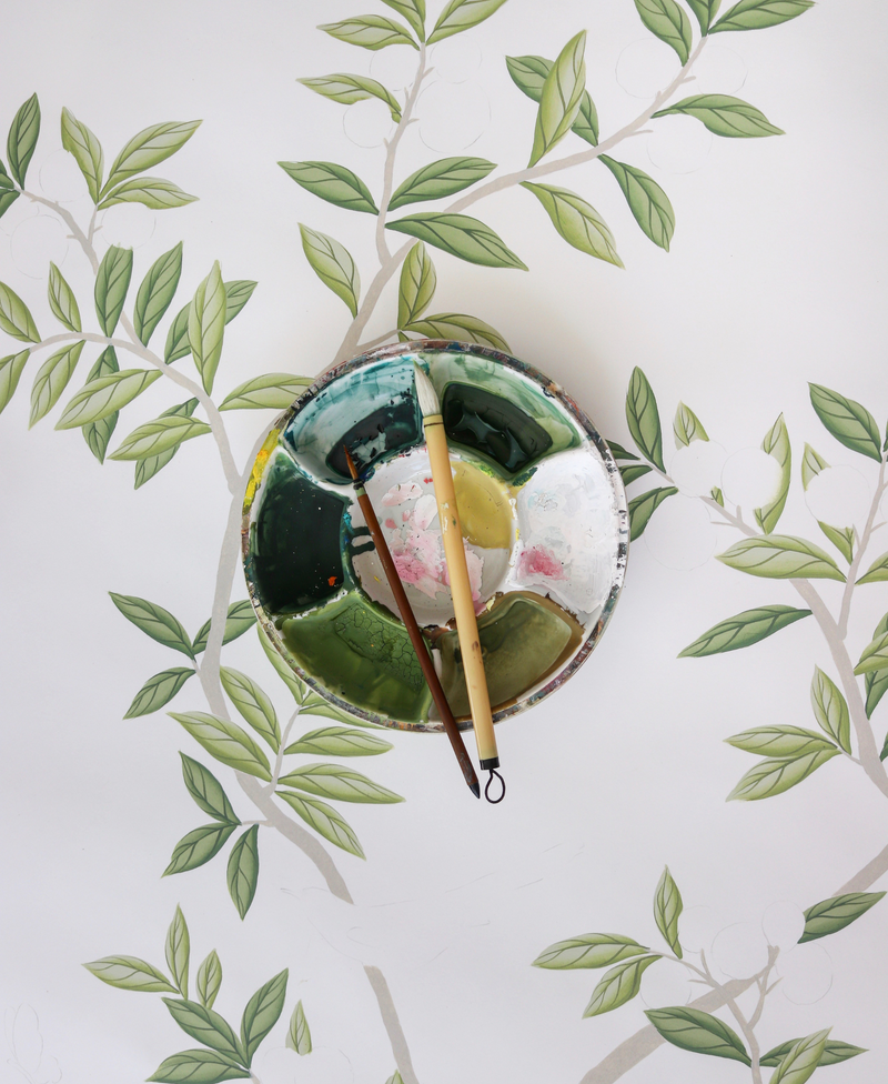 Paint palette and brushes sat on the original design for her 'Chinoiserie Chic' wallpaper in collaboration with Rebel Walls