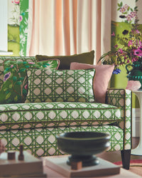 green geometric fabric featuring chinoiserie trellis design on sofa in maximalist living room