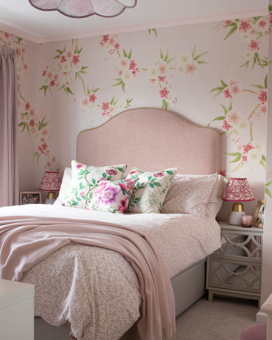 Pink chinoiserie wallpaper mural with light pink and white Japanese cherry blossom flowers in girls bedroom