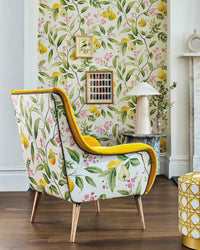 yellow botanical fabric featuring chinoiserie style fruits and flowers on sofa