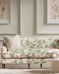 botanical fabric featuring chinoiserie style birds, branches, and butterflies on sofa in modern living room