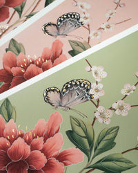 close up of pink and green chinoiserie art prints featuring butterflies and flowers with 24 carat gold embellishements