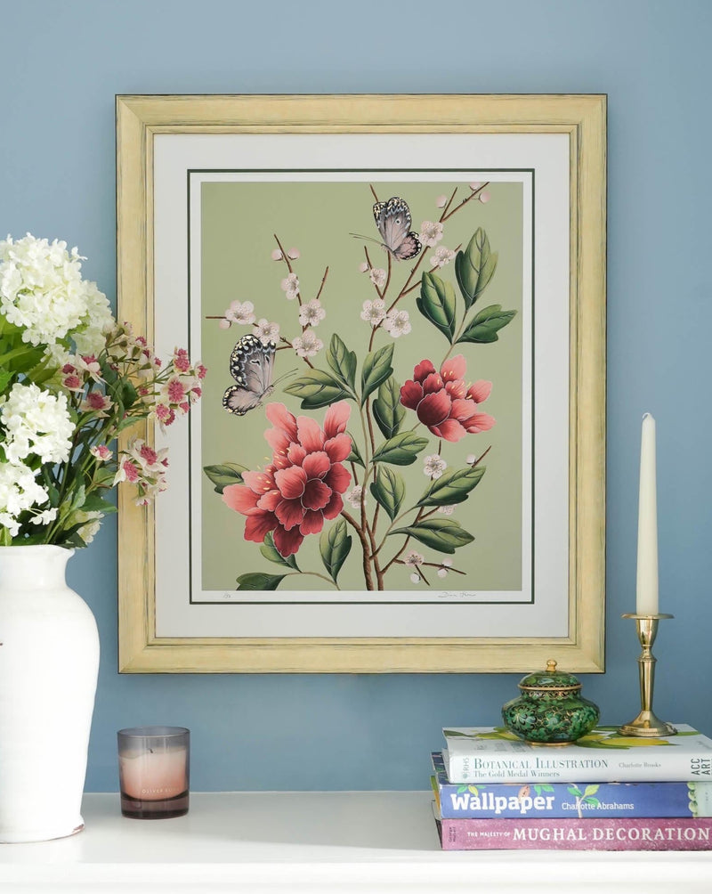 framed green chinoiserie art print featuring red flowers, cherry blossoms, and butterflies on wall