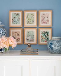 Set of six chinoiserie wall art prints In frames creating a gallery wall in a blue and white living room