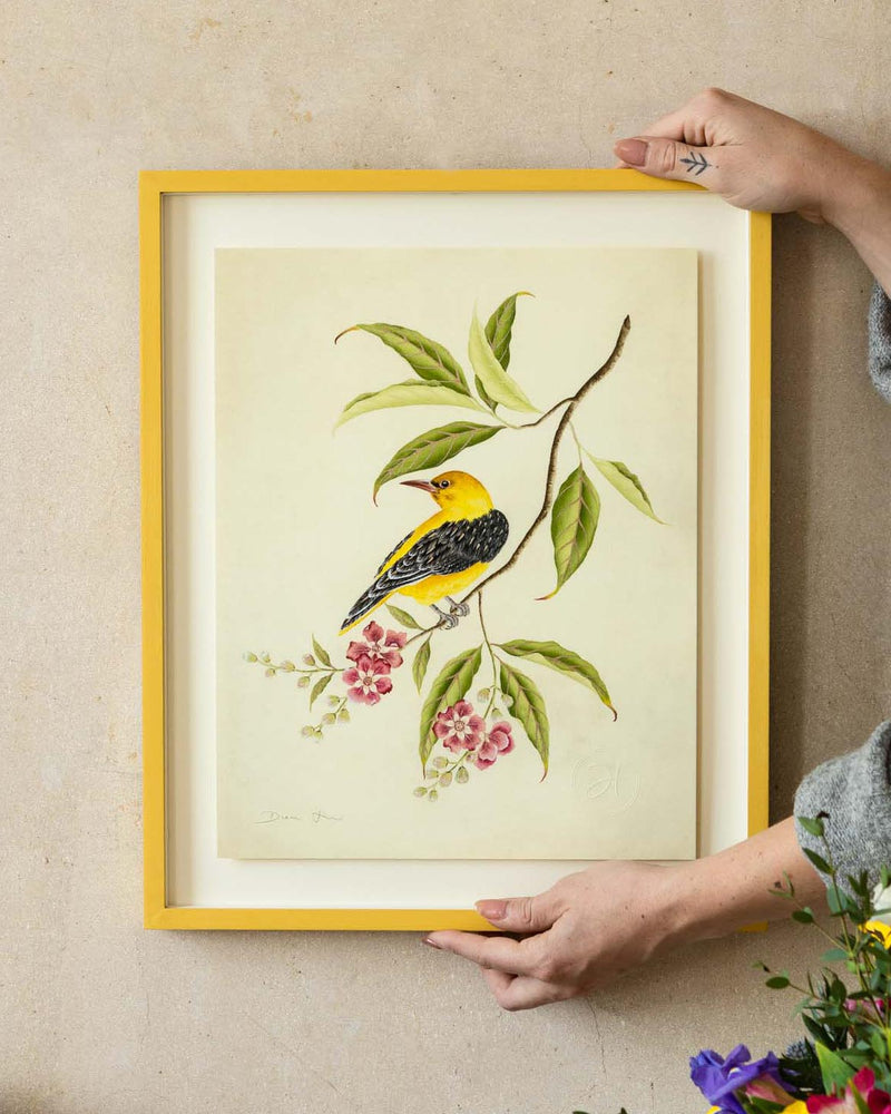 framed botanical wall art print featuring gold sparkle embellished exotic bird on tree branches with flowers hung on wall