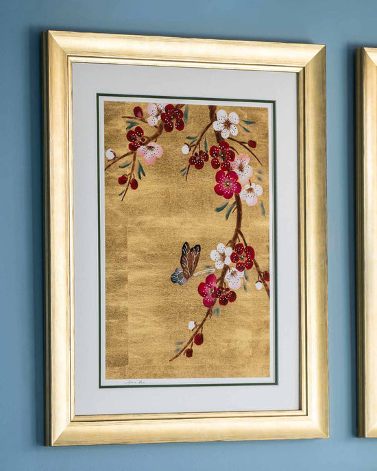 framed chinoiserie wall art print featuring Japanese-style cherry blossom branch and butterfly on gold leaf background hung on wall