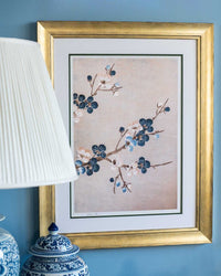 framed chinoiserie wall art print featuring Japanese-style cherry blossom branches on silver background hung on wall