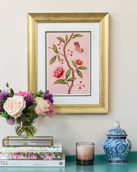 framed chinoiserie wall art print featuring pink vintage-style butterfly and flower branch on pink background hung on wall