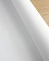 close up image of roll of white silk paper on wooden table