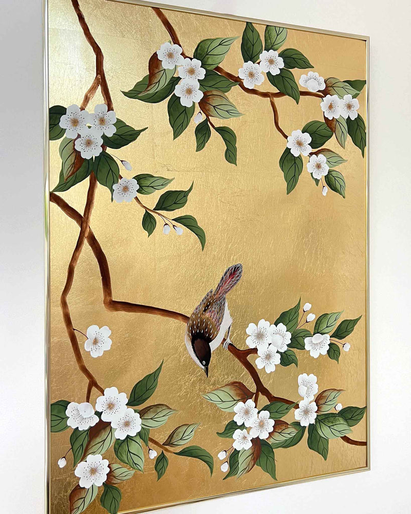 Diane Hill's original chinoiserie painting 'Gold Bird And Blossom Branches' in a gold frame on a plain white wall