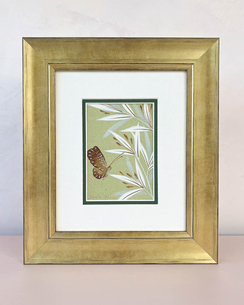 Diane Hill's original chinoiserie painting 'Green Butterfly And Bamboo' in a gold frame on a plain white background