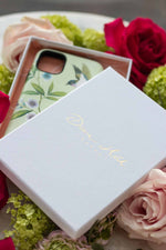 Diane Hill chinoiserie phone case in a gift box on top of flowers