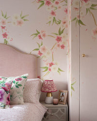 Pink chinoiserie wallpaper mural with light pink and white Japanese cherry blossom flowers in girls bedroom