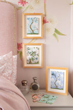 6 chinoiserie mini prints from Diane Hill's 'Faraway Tree' collection, framed and mounted on a bedroom wall and spread out on a dresser