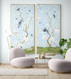 pair of 2 framed blue chinoiserie wall panel prints with botanical illustrations featuring birds, butterflies, and flowers hung on wall