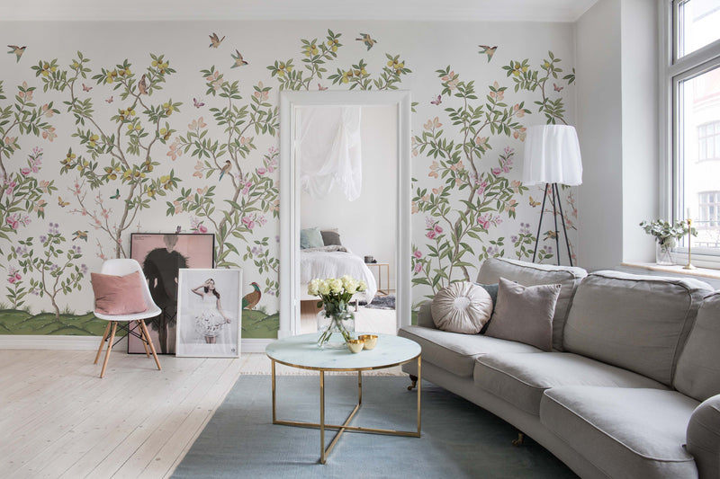 Diane Hill x Harlequin 'Chinoiserie Chic' wallpaper in a living room with sofa, mirror, coffee table, and art prints