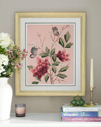 framed pink chinoiserie art print featuring red flowers, cherry blossoms, and butterflies on wall