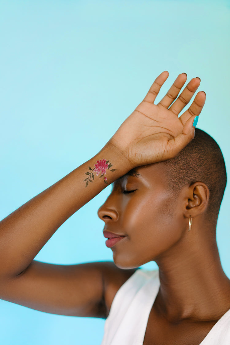 A stunning woman shows off her wrist, bearing Chinoiserie inspired temporary tattoos, design by Diane Hill in collaboration with Tattly